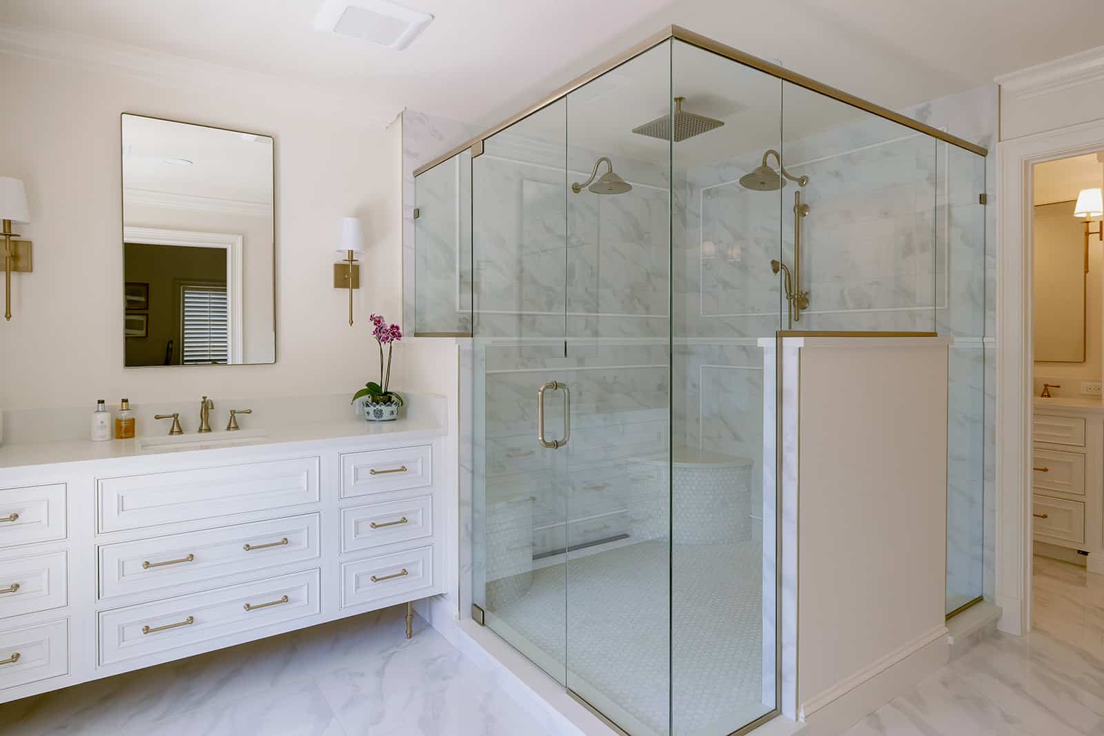 Winter Park primary bathroom remodel with marble tile and glass shower by KBF