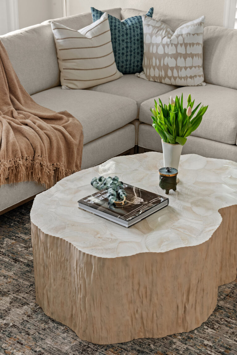 Baldwin Park living room interior design &mdash; capiz-shell coffee table styled with art books and tulips beside the sectional