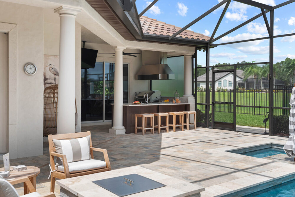 Windermere summer kitchen and deck remodel — the outdoor kitchen bar with stools beside the pool, under the screened lanai