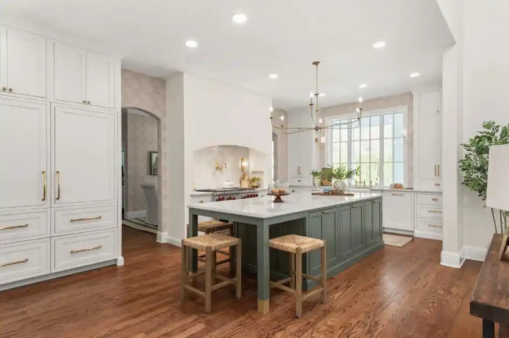 Bright white kitchen with a deep-green island, arched range alcove and warm wood floors &mdash; DeLand kitchen remodel by KBF