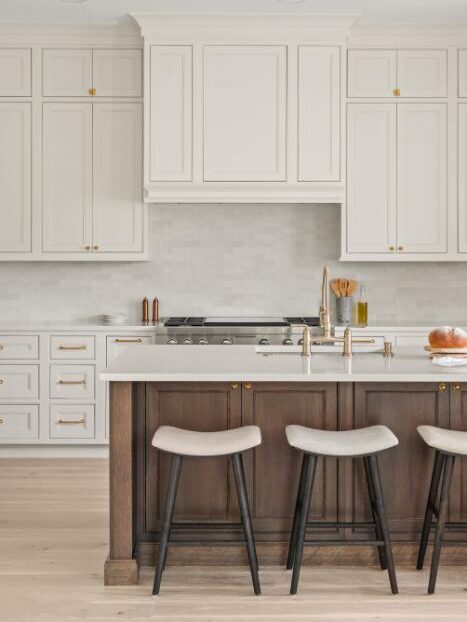 Winter Park kitchen remodel &mdash; the bright kitchen with cream cabinetry, wood island base, and upholstered counter stools