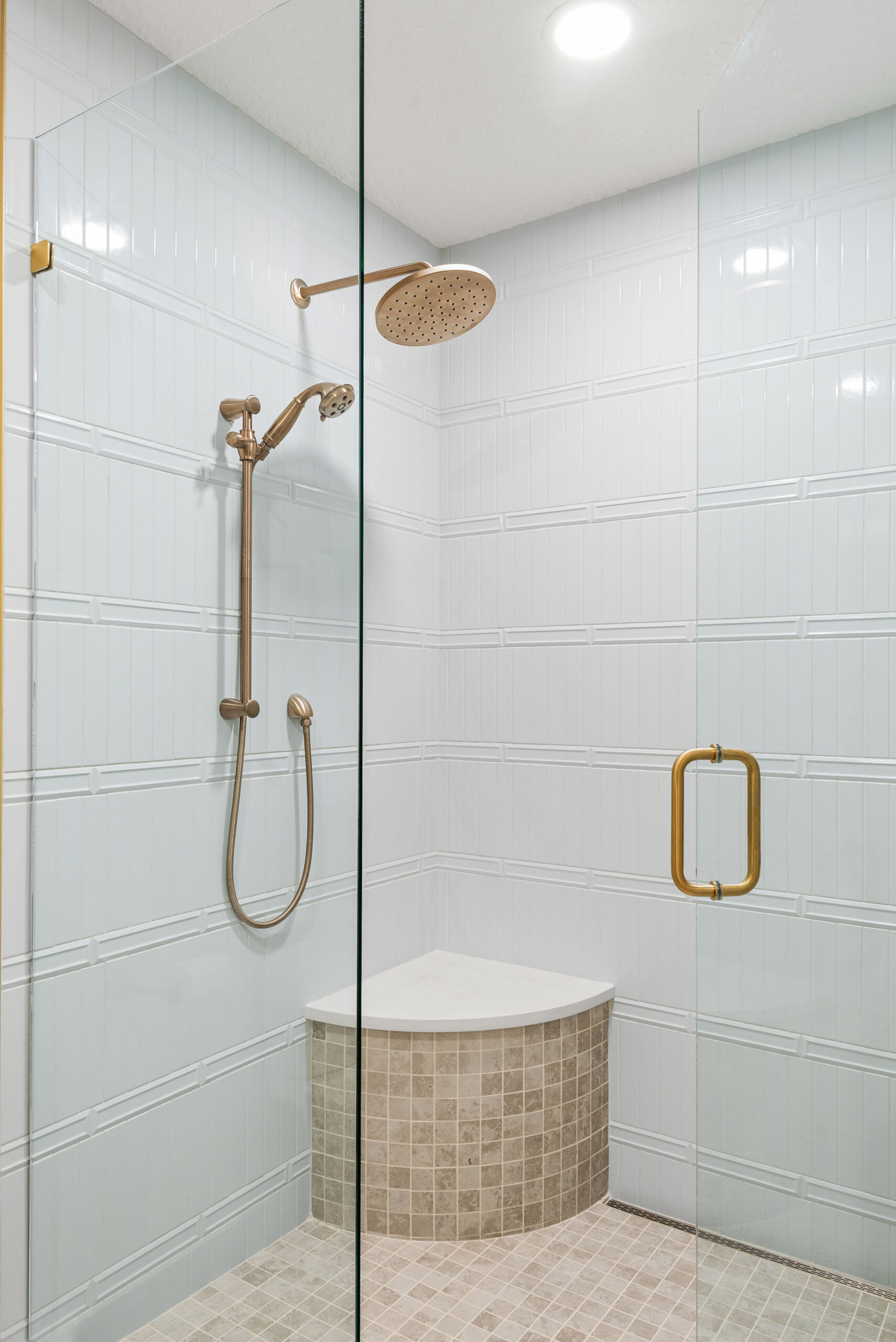 Winter Park whole-home renovation — the completed walk-in shower with bronze rain head and marble-look tile