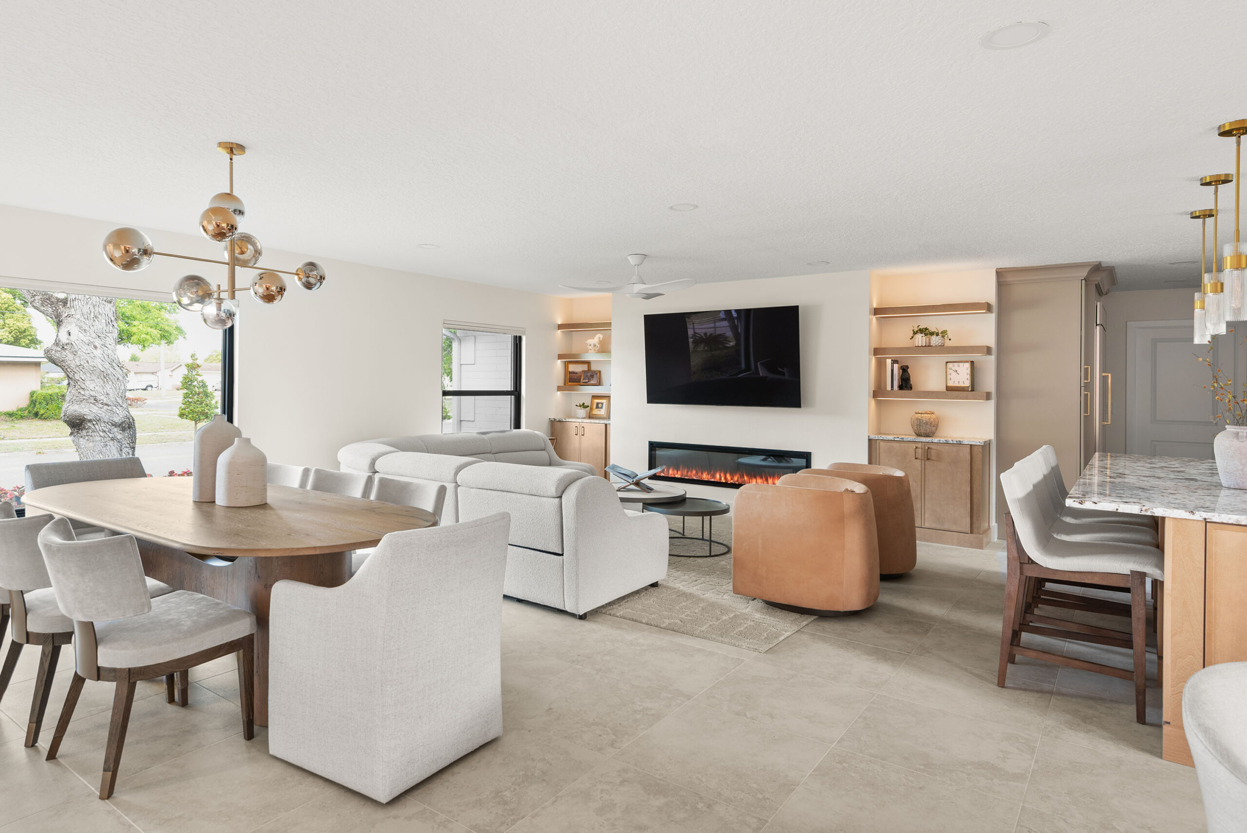 Winter Park whole-home renovation — the living room with linear fireplace and built-ins, the kitchen island visible beyond