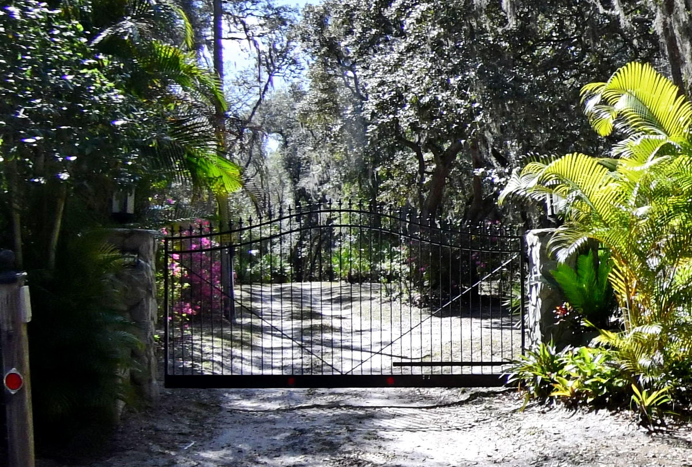 Iron gate entrance to the Oak Hollow Lane estate on Lake Marie in Oviedo, Florida &mdash; a KBF Design Gallery interior remodel helped this 4,845-square-foot property achieve the street's highest price per square foot at $343.