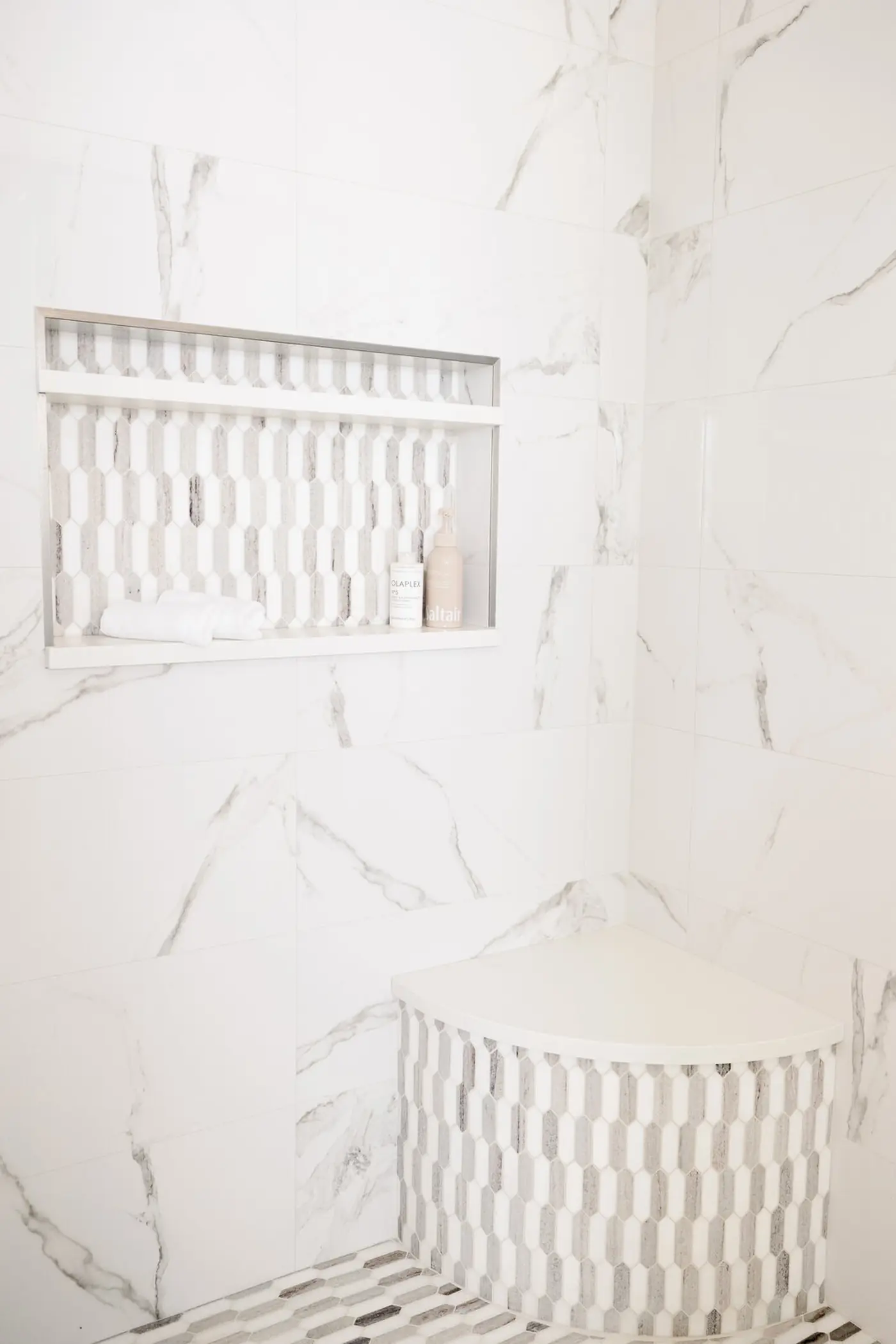 The marble-look shower with mosaic niche