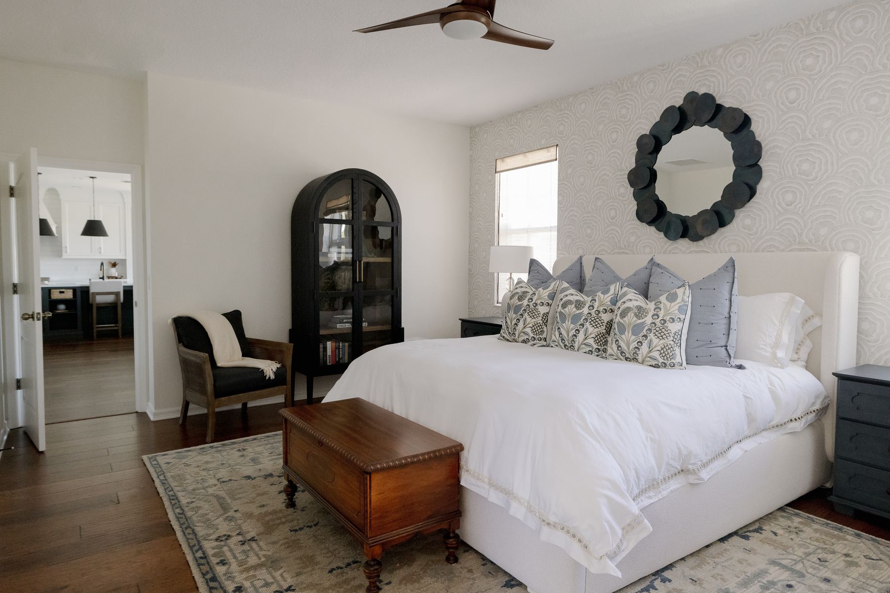 The whole-home remodel in Apopka — primary suite with the kitchen visible through the open door