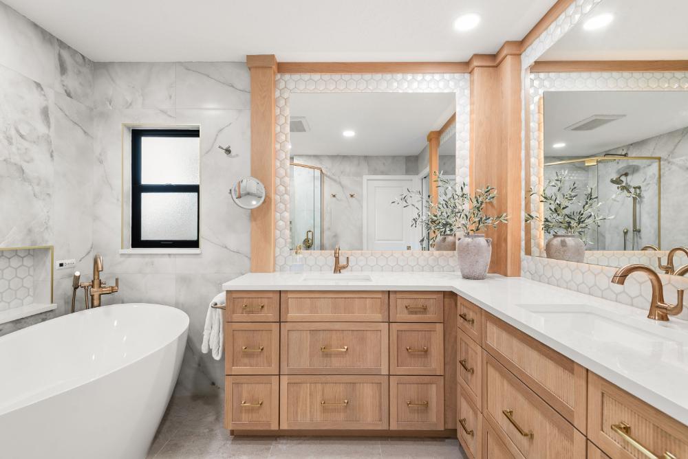 White oak double vanity with fluted drawers and brass fixtures in a Lake Mary primary bathroom remodel by KBF Design Gallery