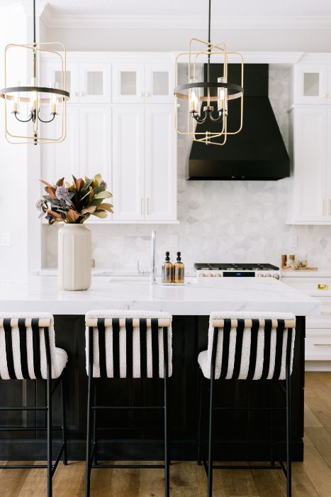 Lake Mary kitchen remodel with a black island, striped counter stools, black range hood, and brass lantern pendants by KBF Design Gallery