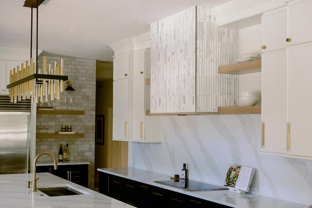 Veined quartz slab backsplash and brass hardware in a Maitland kitchen remodel by KBF Design Gallery