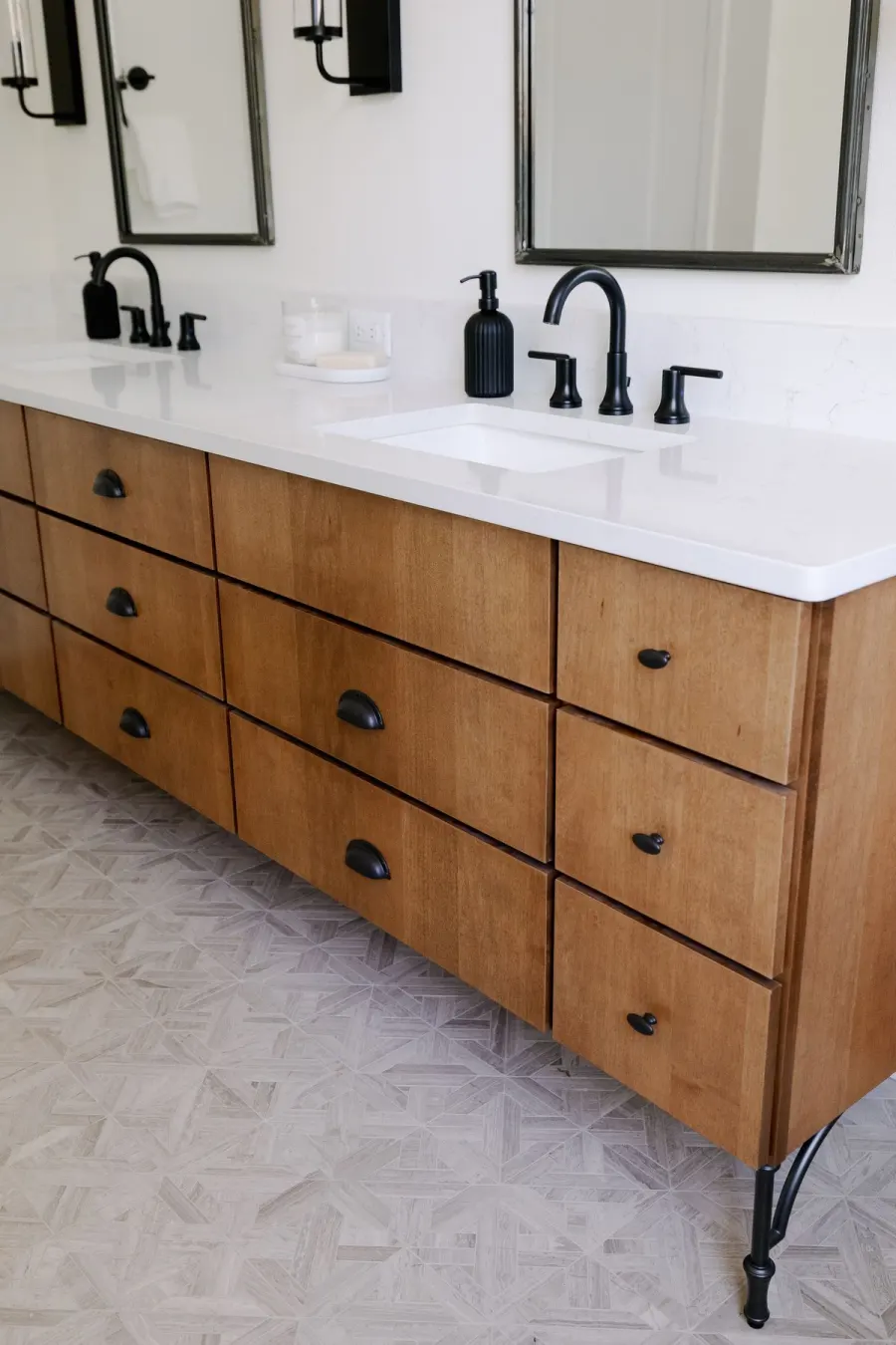 The bathroom vanity &mdash; warm wood drawers, black fixtures