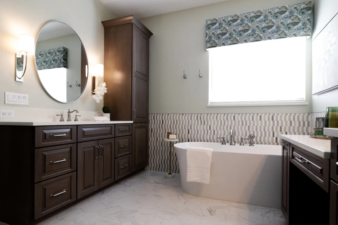 The master bath after completion &mdash; freestanding tub, patterned tile wainscot, dark wood vanities, custom valance