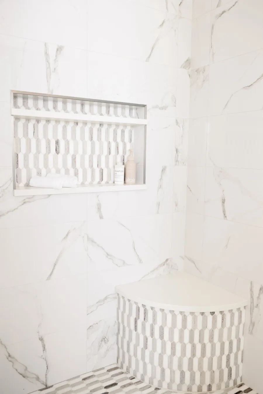 The marble-look shower with mosaic niche