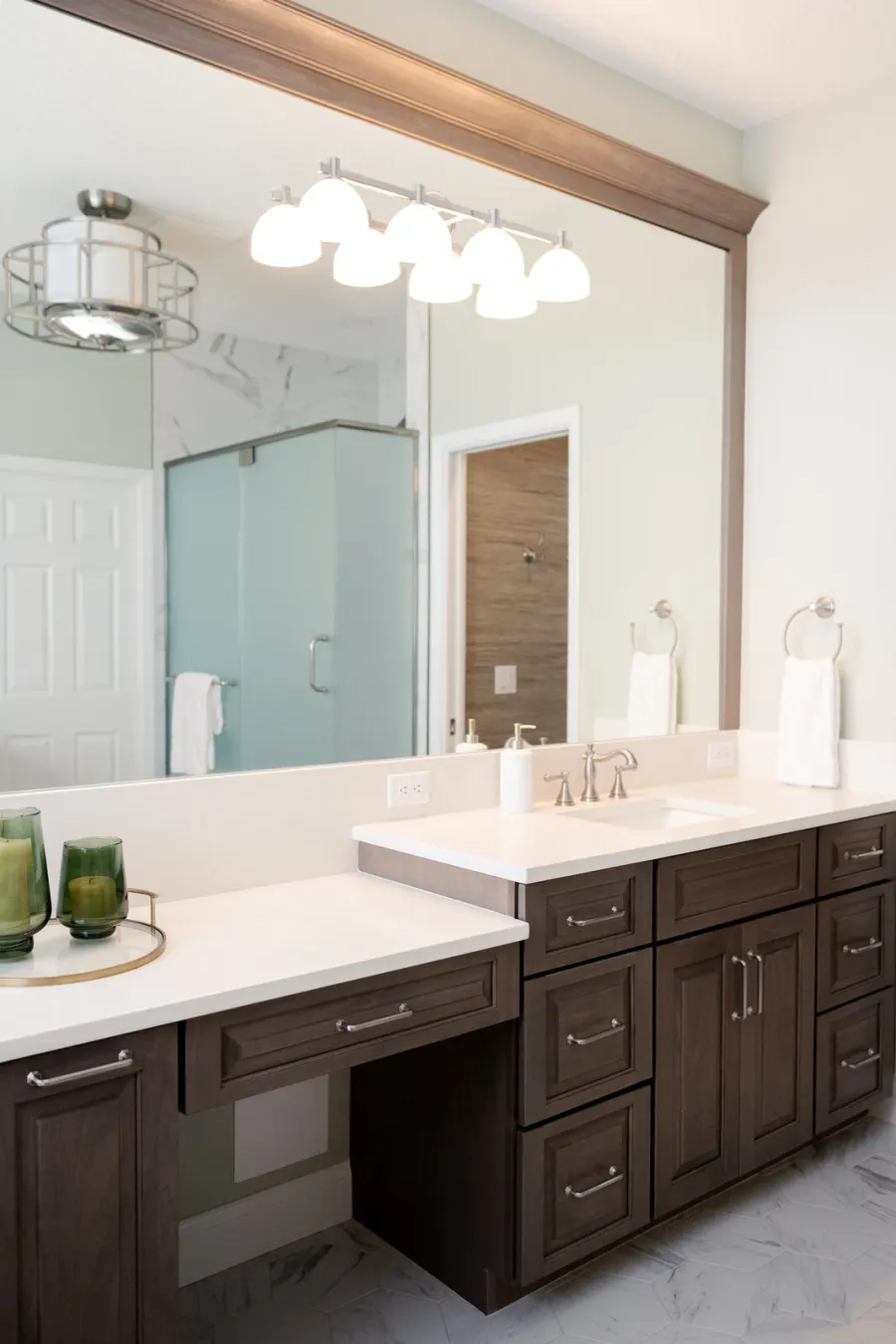 The vanity wall &mdash; framed mirror, white quartz, sconce lighting