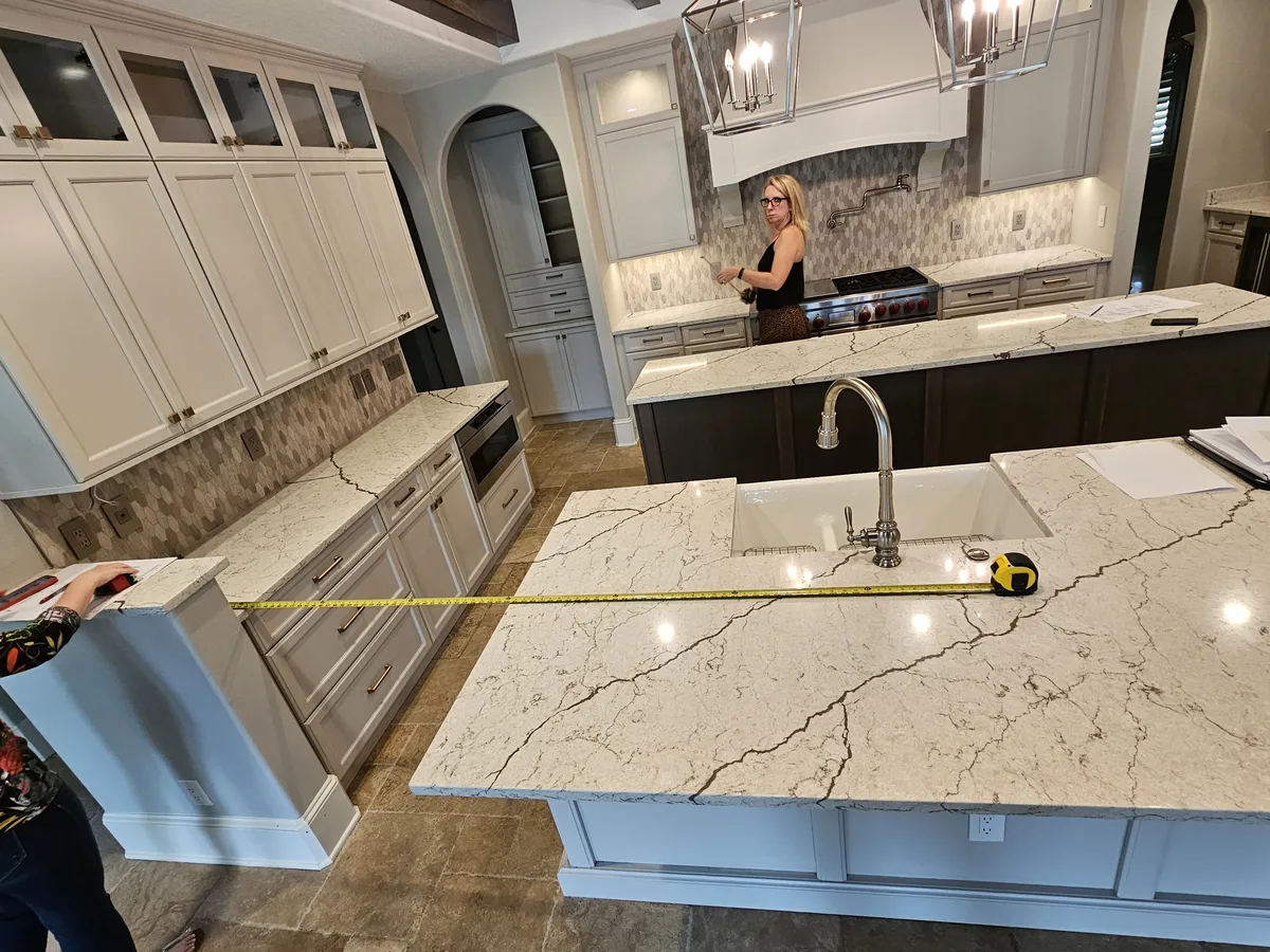 The kitchen before the remodel — cream raised-panel cabinets and busy granite counters