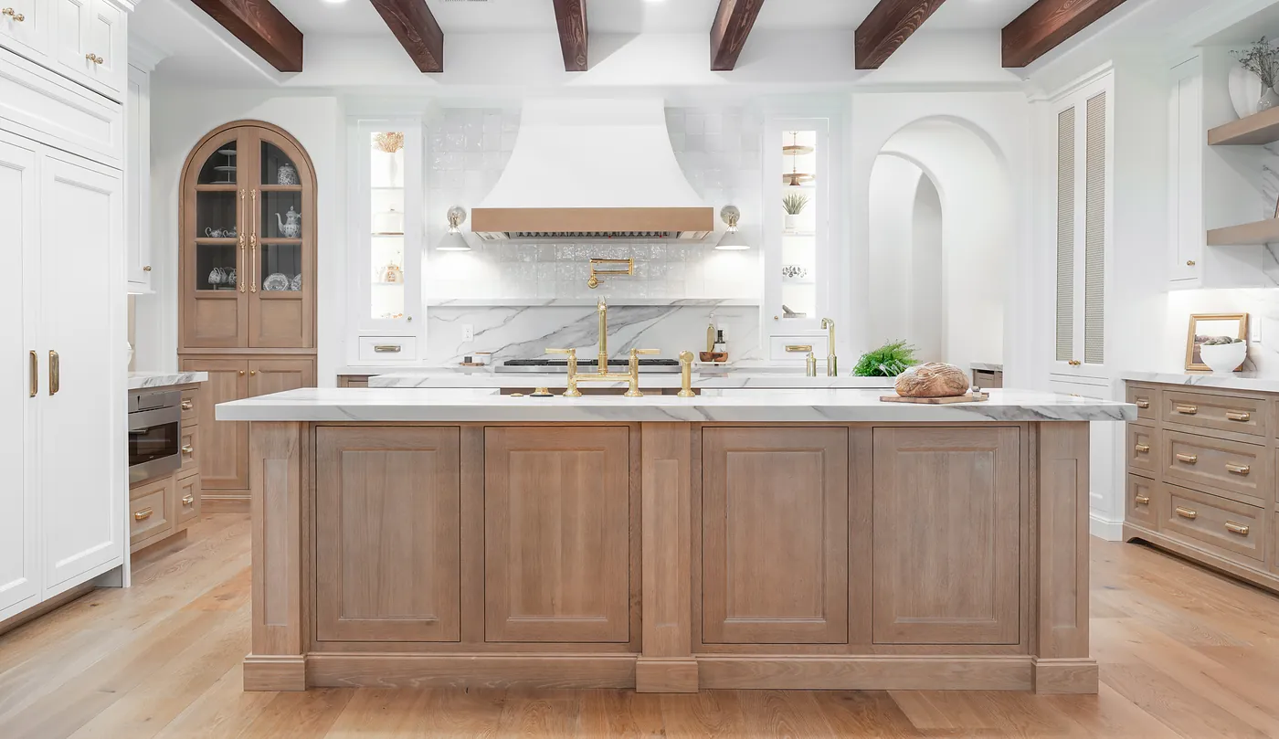 A finished KBF kitchen — rift-cut oak island and base cabinetry, painted perimeter cabinets, a custom hood and veined stone counters, Central Florida