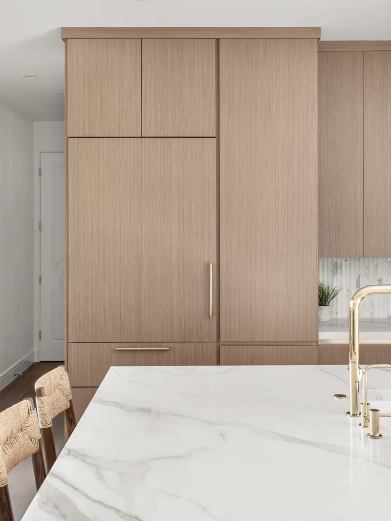 The integrated Thermador refrigerator paneled into the tall cabinet bank with a long brass pull