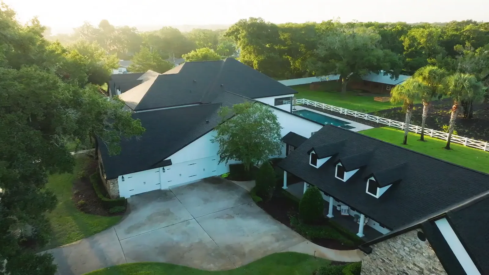 A completed KBF whole-home estate remodel in Windermere, Florida — the rebuilt rear elevation, pool, and grounds at first light