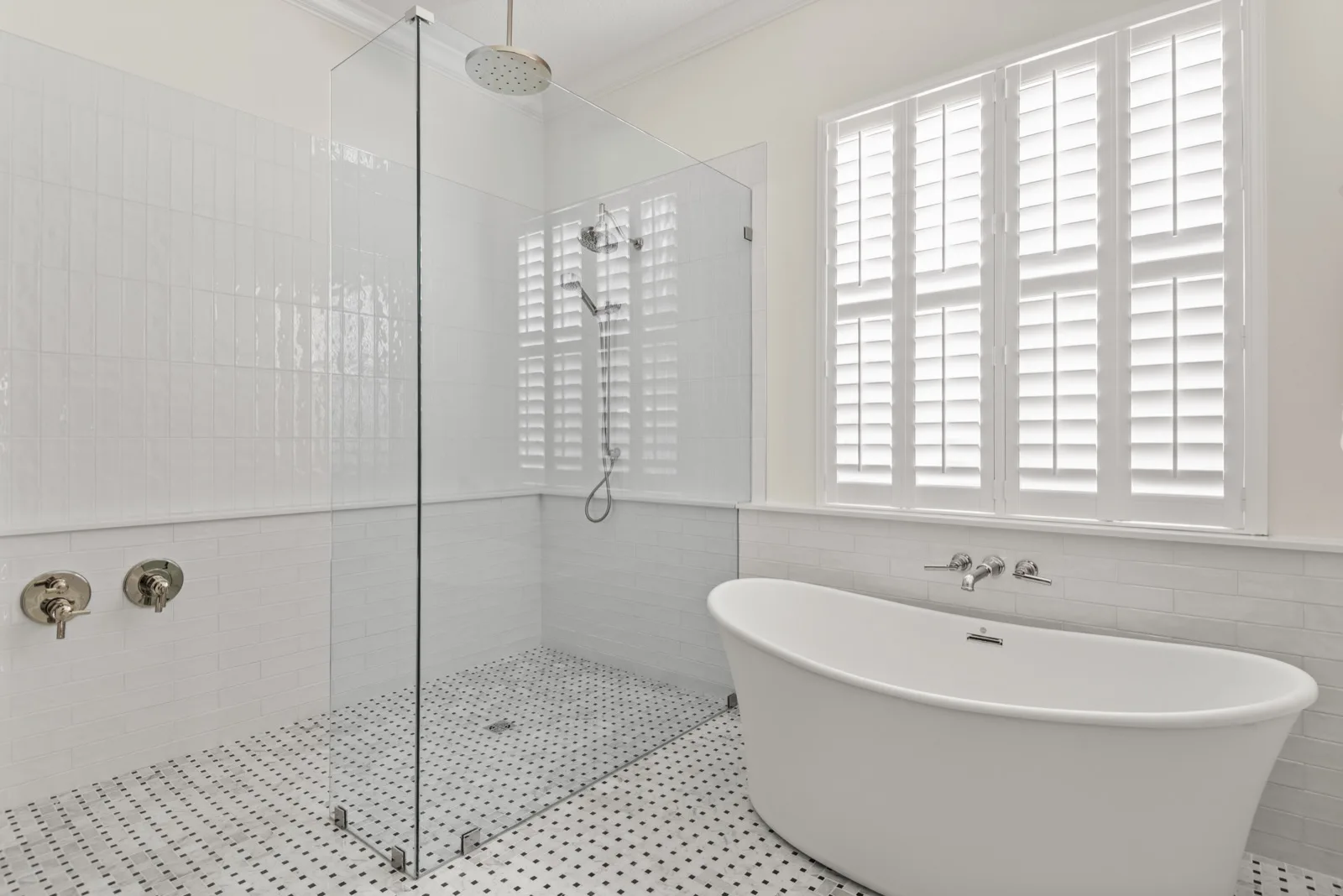 Winter Park bath remodel — walk-in shower and freestanding soaking tub under plantation shutters