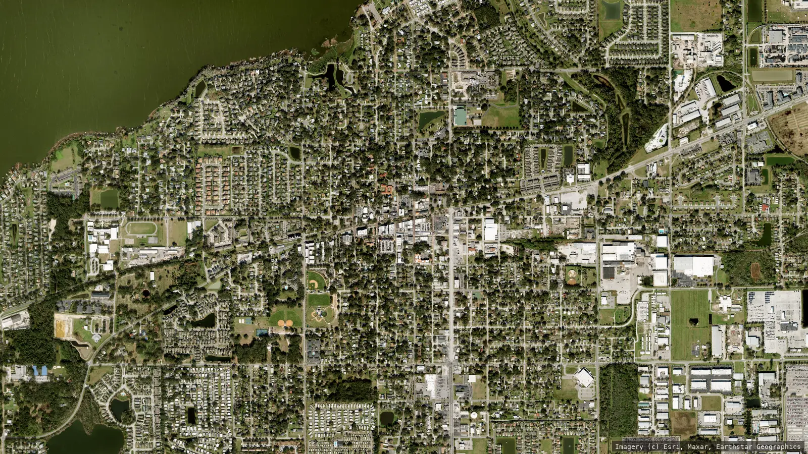 Satellite view of Winter Garden, Florida from neighborhood altitude &mdash; the Plant Street historic district grid, the Lake Apopka shoreline and tree canopy. Imagery &copy; Esri, Maxar, Earthstar Geographics