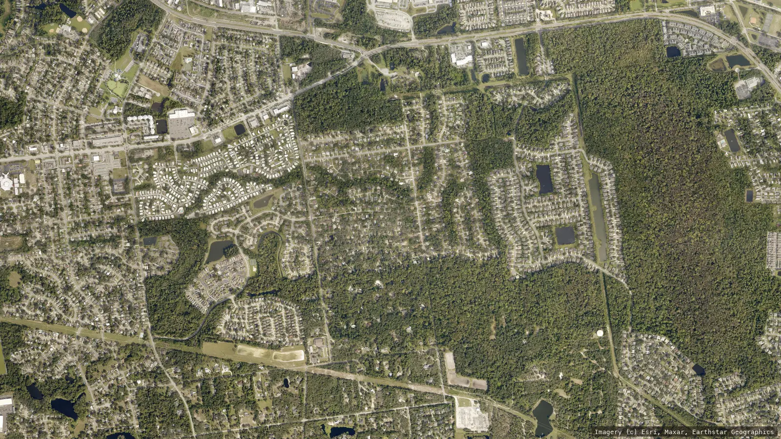 Satellite view of Winter Springs, Florida from neighborhood altitude &mdash; the SR 434 corridor, Town Center, tree canopy and master-planned subdivisions. Imagery &copy; Esri, Maxar, Earthstar Geographics
