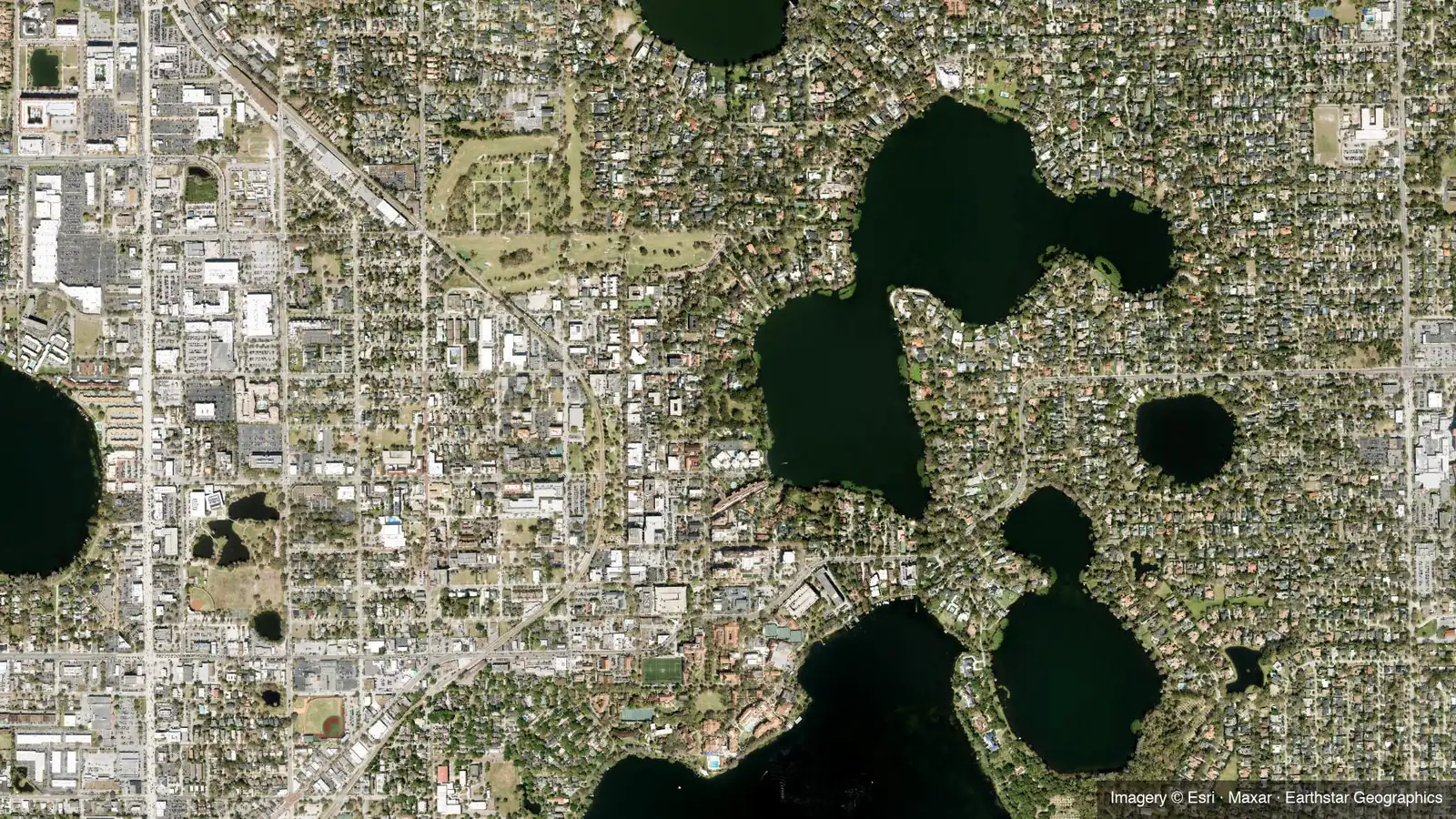 Satellite view of Winter Park, Florida &mdash; the chain of lakes, Park Avenue, and the tree-canopied neighborhoods around them. Imagery &copy; Esri, Maxar, Earthstar Geographics
