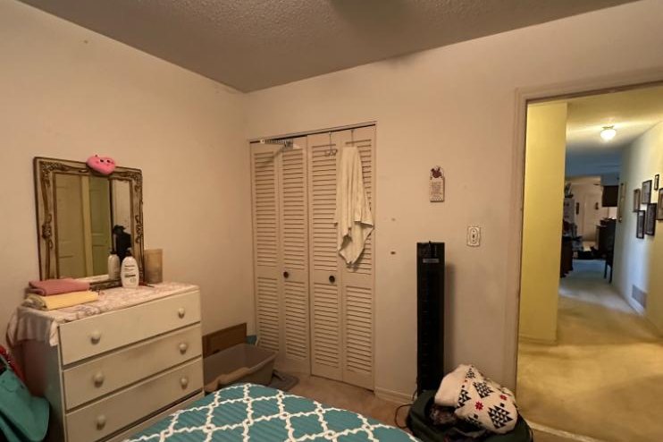 The spare bedroom before the remodel, with louvered bifold closet doors and a doorway to the hall; this room became the new primary bathroom